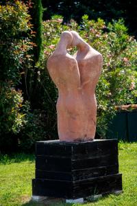 a statue of a woman sitting on a pedestal in the grass at Relais Villa Isabel in Pietrasanta