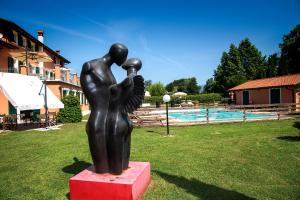 a statue of two people standing next to a pool at Relais Villa Isabel in Pietrasanta