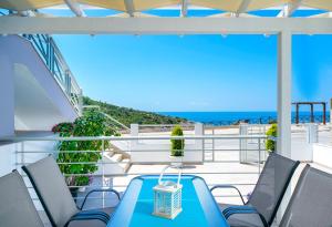 een balkon met een blauwe tafel en stoelen en de oceaan bij Tarsa's House by the Sea in Skala Marion