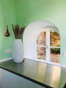 a white vase sitting on a counter with a window at Stadsvilla met patio in centrum Maastricht in Maastricht