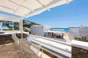 a balcony with chairs and a view of the ocean at Miles Away Sifnos - Beachfront House in Platis Gialos