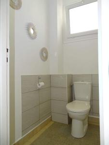 La salle de bains est pourvue de toilettes blanches et d'une fenêtre. dans l'établissement L'Agapanthe 3 étoiles Joli appartement en bord de mer, à Dieppe