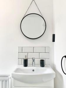 a white bathroom with a sink and a mirror at Snowdonia Retreat in Trefriw