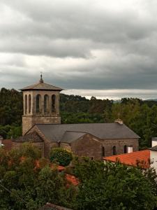eine alte Kirche mit einem Uhrturm in der Ferne in der Unterkunft Pensión KM66 Palas de Rei in Palas de Rei