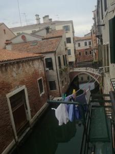 a view of a canal with clotheslines and a bridge at Casa pergoletto in Venice