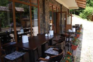 a restaurant with wooden tables and chairs and windows at Hotel Dykyi Med in Tatariv