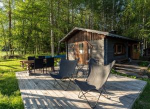 Cabaña de madera con sillas, mesa y mesa de picnic en Laawu Kultainkoski en Kotka