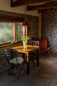 a wooden table with a vase of flowers on a porch at Laawu Kultaa in Kotka