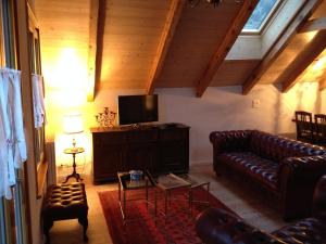 a living room with leather couches and a flat screen tv at Haus am See in Därligen