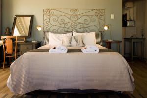 a bedroom with a large bed with towels on it at Dreamy Beach Room in Melkbosstrand