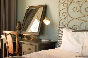um quarto com uma cama e um espelho numa cómoda em Dreamy Beach Room em Melkbosstrand