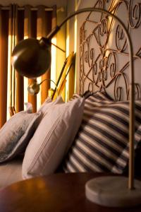 Una cama con almohadas y una lámpara. en Dreamy Beach Room en Melkbosstrand