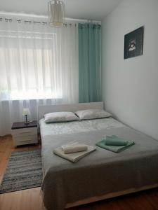 
A bed or beds in a room at Pomaranczowa Apartment
