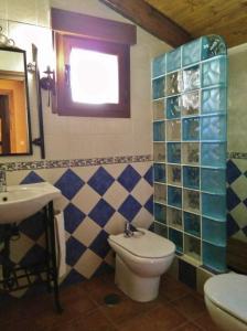 y baño con aseo y lavamanos. en Casa Rural Albarranco, en Prádena de Atienza