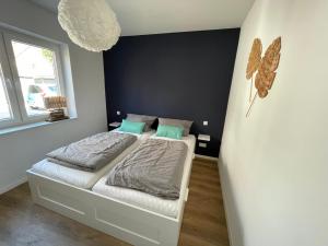 una piccola camera da letto con letto e cuscini verdi di Fewo Lieblingsort Norddeich a Norddeich