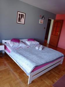 1 dormitorio con 1 cama grande con almohadas rosas en Apartament Pod Leszczyną, en Sandomierz