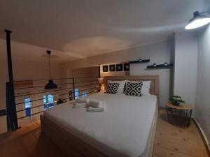 a bedroom with a large white bed and a balcony at Speri's Loft in Preveza