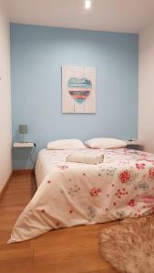 a bedroom with two beds and a painting on the wall at O Ninho in Vila Nova de Gaia