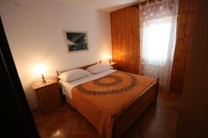 a bedroom with a bed and a window and two lamps at Apartments Ivancevic in Korčula