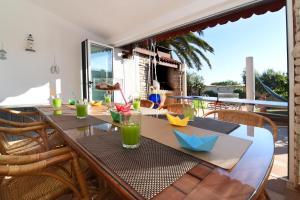 drewniany stół z krzesłami i stół z napojami w obiekcie Holiday Home Villa Margherita w Puli