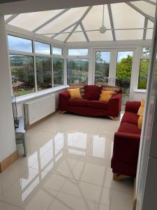 a living room with a red couch and windows at Figart Cottage in Fegart