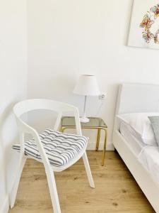 una silla blanca sentada junto a una mesa con una cama en Apartmani Stupin Čeline, en Podglavica