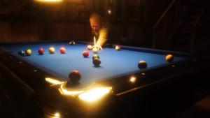 a man is playing pool on a pool table at Gudvangen Camping in Gudvangen