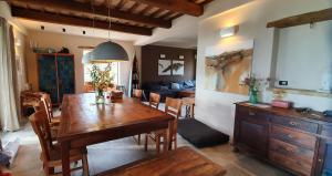 a dining room and living room with a wooden table at Lemonvilla - Rustico in Panoramalage in Castignano