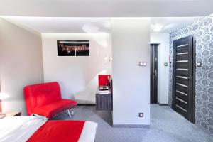 Un dormitorio con una silla roja y una cama en Apartament Podwale, en Łańcut