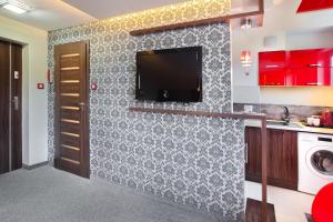 a kitchen with a tv on a wall at Apartament Podwale in Łańcut +13 photos