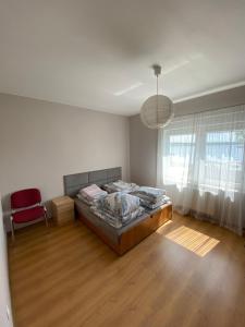 sypialnia z łóżkiem i czerwonym krzesłem w obiekcie Apartament U rybaka w mieście Stężyca