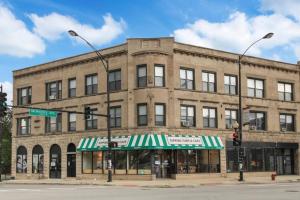 duży ceglany budynek na rogu ulicy ze sklepem w obiekcie 3BR Apt in Logan Square Walkable to Highlights - Central Park S6 w Chicago