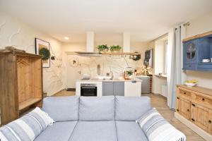 a living room with a couch and a kitchen at Apartament Nieoczywisty in Stronie Śląskie +12 photos