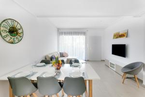 a white dining room with a white table and chairs at Bahia Homes Residencial in La Horadada