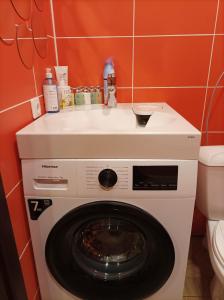 eine Waschmaschine mit einem Waschbecken darüber in der Unterkunft Laisvės 10 in Telšiai