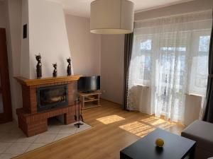 salon z kominkiem i telewizorem w obiekcie Apartament U rybaka w mieście Stężyca