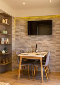 a dining room with a table and chairs and a television on a wall at Eleni's Cozy House in Agios Nikolaos