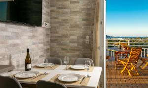 a dining room with a table with a bottle of wine at Eleni's Cozy House in Agios Nikolaos