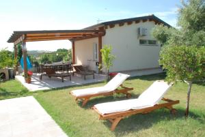 eine Terrasse mit 2 Stühlen und einem Tisch im Hof in der Unterkunft Paraiso in Mafalda