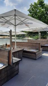 une table avec un parasol blanc sur un bateau dans l'établissement Seestern - Ferienhaus am Quendorfer See (Nr. 5), à Schüttorf 19 autres photos