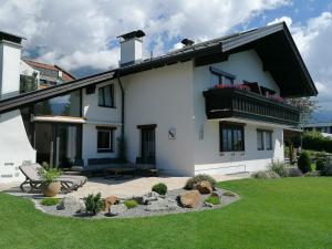 a white house with a bench in a yard at Landhaus Plainer in Innsbruck