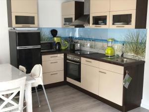 a kitchen with white and black appliances and a table at Meeresrauschen in Graal-Müritz