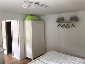 a bedroom with a white cabinet and a bed at Meeresrauschen in Graal-Müritz