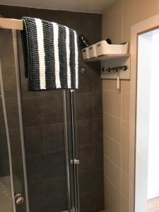 La salle de bains est pourvue d'une douche et d'une serviette noire et blanche. dans l'établissement Meeresrauschen, à Graal-Müritz