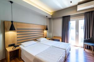 a hotel room with two beds and two lamps at Agamemnon Hotel in Nafplio