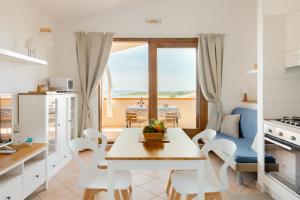 a kitchen and dining room with a table and chairs at Villa Laura in Villaputzu