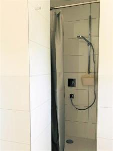 a shower with a shower curtain in a bathroom at urbanAPARTMENT No.1 Memmingen in Memmingen
