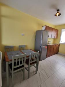 a kitchen with a table and a stainless steel refrigerator at Glasgow Apartment Cozy and ultramodern in Glasgow