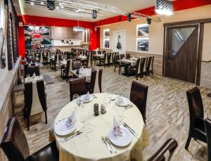 a dining room with tables and chairs and red walls at Tinódi Fogadó in Sárvár