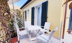 a patio with white chairs and a table at Affittacamere L'Orto dei nonni in Levanto